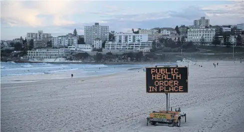 ?? REUTERS ?? A public health message is seen on Bondi Beach in Sydney, Australia.