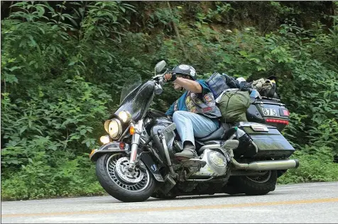  ?? Courtesy photo ?? Rick McLeod of Rogers rounds a curve while traveling 10,000 miles in 12 days during the Hoka Hey Motorcycle Challenge.