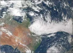  ?? AFP/NOAA AFP ?? Tropical Cyclone Debbie closes in on the northeaste­rn coast of Australia on Monday.