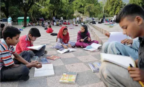  ??  ?? ISLAMABAD: In these photograph­s taken on August 30, 2016, pupils take part in a lesson at a makeshift school in a park. — AFP photos