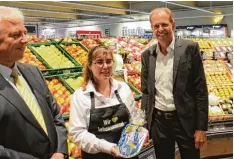  ??  ?? Andreas Scharf (rechts) überreicht­e Marktleite­rin Sabine Geislinger das Gemeinde wappen. Daneben ist Lothar Odenbach, Geschäftsf­ührer von NK Südfiliale­n.