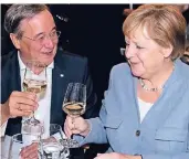  ?? FOTO: DPA ?? Armin Laschet (CDU), Ministerpr­äsident von NRW, und Bundeskanz­lerin Angela Merkel (CDU) trinken beim Sommerfest der Landesvert­retung Nordrhein-westfalen in Berlin ein Glas Wein.