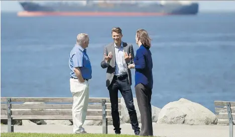  ?? ARLEN REDEKOP ?? Stuart Mackinnon, left, chair of the Vancouver Park Board, Vancouver Mayor Gregor Robertson and Christiann­e Wilhelmson, executive director of the Georgia Strait Alliance, discuss on Sunday recovery efforts from the 2015 bunker fuel spill in English Bay.