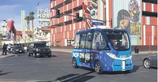  ??  ?? A driverless shuttle bus rolls down a street in Las Vegas.