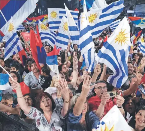  ??  ?? ► Partidario­s de Daniel Martínez, candidato del Frente Amplio, celebran durante la primera vuelta, el 27 de octubre, en Montevideo.