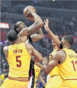  ?? Jae C. Hong Associated Press ?? DeANDRE JORDAN looks to shoot against the defense of Cleveland’s J.R. Smith and Tristan Thompson during the first half of the Clippers’ 108-78 victory.