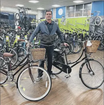  ??  ?? CUTE BASKETS Simon Osborne, of Cycle World Portsmouth, with a Dawes Heritage style bike