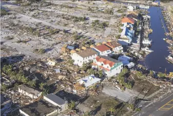  ?? Mark Wallheiser / Getty Images ?? An aerial view shows how Hurricane Michael obliterate­d dozens of homes and businesses in Mexico Beach, Fla. At least 14 people have been killed throughout the storm’s vast path.