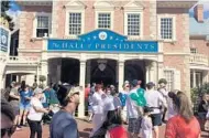  ?? GABRIELLE RUSSON/STAFF ?? Visitors stroll by the Hall of Presidents at Magic Kingdom. For some parkgoers, Monday marked the first time seeing the attraction’s latest arrival — animatroni­c President Donald Trump.