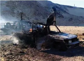  ?? (Reuters) ?? DESTROYED VEHICLES of an Egyptian police convoy, which came under fire from a heavily armed terrorist group, lie in the desert at the Bahariya Oasis in the Western Desert.