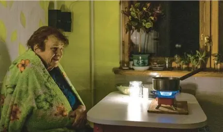  ?? ANDREW KRAVCHENKO/AP ?? An elderly woman cooks a meal on a gas burner during a blackout last week in Kyiv. The power situation has deteriorat­ed in Ukraine.