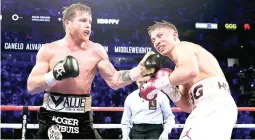  ??  ?? Canelo Alvarez, left, lands a punch against Gennady Golovkin in the 12th round during their middleweig­ht title match Saturday in Las Vegas. Alvarez won by majority decision. (AP)