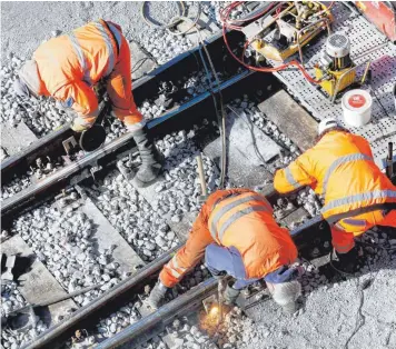  ?? FOTO: ROLAND WEIHRAUCH/DPA ?? Teuer, aber notwendig: Ein Bautrupp der Deutschen Bahn repariert das Gleisbett.