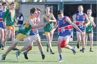  ??  ?? Bunyip’s Heath Morgan-Morris gets his kick away under pressure.