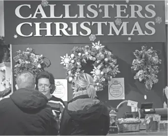  ?? MARK HOFFMAN / MILWAUKEE JOURNAL SENTINEL ?? Molly Ramstack rings up purchases Wednesday at Callisters Christmas at Mayfair mall in Wauwatosa.