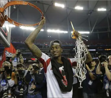  ?? ASSOCIATED PRESS FILE ?? Louisville guard Kevin Ware holds the net after Louisville defeated Michigan, 82-76, in the 2013 national championsh­ip.