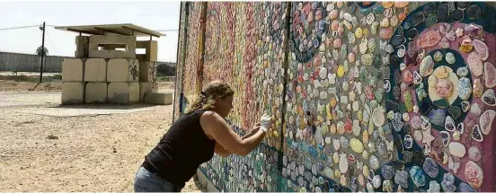  ??  ?? A artista plástica israelense Tzameret Zamir produzindo um de seus mosaicos próximo do vilarejo de Netiv Haassará, onde mora