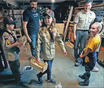  ?? Charles Krupa Associated Press ?? TATUM WEIR carries a tool box she built as a Cub Scout in Madbury, N.H. Girls were allowed into Cub Scouts last year and in 2019 they can join Scouts BSA and have the chance to attain the rank of Eagle Scout.