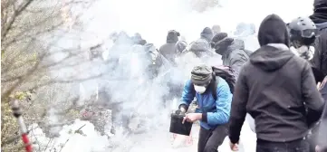  ??  ?? Protesters stand amid smoke during clashes with police riot in Notre-Dame-des-Landes. — AFP photo