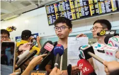  ??  ?? HONG KONG: Hong Kong democracy campaigner Joshua Wong (C) stands next to recently-elected lawmaker Nathan Law (R) as he holds up his expulsion order from Thai authoritie­s during a press conference upon his arrival at the internatio­nal airport in Hong...