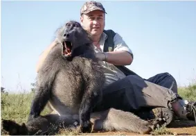  ??  ?? Kill: Mr Sailor shows off a dead baboon on one of his expedition­s