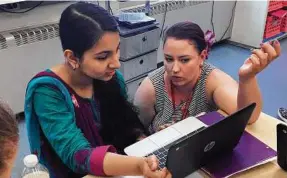  ??  ?? Teacher Gianna Gurga, right, talks with student Maisha Chowdhury Jabia in a class on financial literacy at Dag Hammarskjo­ld Middle School in Wallingfor­d, Conn.