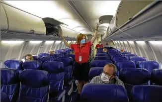  ?? CHARLIE RIEDEL/ ASSOCIATED PRESS ?? ASouthwest­Airlines flight attendant prepares a near- empty plane bound for Orlando for takeoffinM­ay at Kansas City Internatio­nal Airport in Kansas City, Mo.