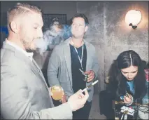  ??  ?? Guests sample marijuana vape pens from Bloom, a sponsor, at a home on the market in Los Angeles.