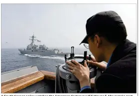  ?? SOUTH KOREAN DEFENSE MINISTRY / VIA AP ?? A South Korean sailor watches the American destroyer USS Wayne E. Meyer take part Tuesday in joint South Korean-U.S. military exercises in South Korea’s West Sea. A U.S. guided-missile submarine arrived in the area Tuesday, and North Korea conducted livefire artillery drills as tensions on the peninsula rose.