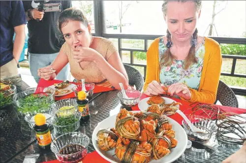  ?? PROVIDED TO CHINA DAILY ?? Foreign visitors enjoy crabs in Jiangsu province, a must-try in fall.