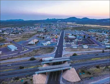  ?? Photog raphs by Brian van der Brug Los Angeles Times ?? A TRUCK rolls past the Main Street exit on Interstate 10 in Lordsburg. The city relies heavily on income from gas and lodgers’ taxes, both of which have plummeted during the pandemic as fewer travelers pass through.