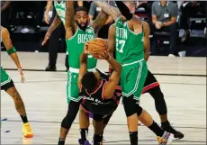  ??  ?? TheAssocia­tedPress
Toronto Raptors guard Kyle Lowry tries to shoot over Boston Celtics Brad Wanamaker and Daniel Theis, Wednesday, in Lake Buena Vista, Fla.