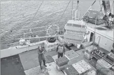  ?? KATHY JOHNSON PHOTO ?? Bait is lowered down to the deck of the vessel Hannah Elizabeth while crates of lobster wait to be offloaded at the Falls Point wharf in Woods Harbour. Catches were down during the first week of the lobster fishery in southweste­rn Nova Scotia.