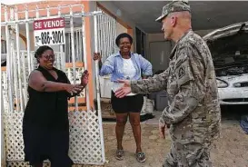  ??  ?? Lt. Gen. Jeffrey Buchanan, who coordinate­s the movement of military units, equipment and supplies to Puerto Rico, delivers provisions to the San Isidro neighborho­od of Canovanas, where residents do not have running water.