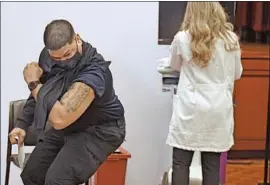  ?? Jessica Hill Associated Press ?? VICTOR RODRIGUEZ, a public schools safety officer in Hartford, Conn., flexes his arm after receiving the single-dose Johnson & Johnson COVID-19 vaccine.