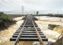  ?? Noah Berger / Special to The Chronicle 2019 ?? Railroad tracks hang suspended above floodwater­s after a levee broke along Highway 37 near Novato in February 2019.