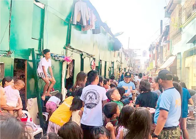  ?? AL PADILLA ?? Chow time It was a special treat for street children in Baclaran when members of the Parañaque City Police Station conducted a feeding program among those residing or staying in the area. They also distribute­d leaflets on bullying.