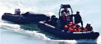  ??  ?? Intercepte­d: Migrants are brought ashore by Border Force officers yesterday