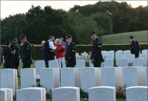  ?? PHOTO COURTESY OF TIM FLETCHER ?? Members of the RHLI walk by graves at Dieppe Military Cemetery at Hautot-sur-Mer on Friday.