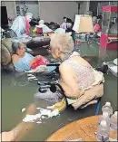  ?? [TRUDY LAMPSON] ?? Residents of the La Vita Bella nursing home in Dickinson, Texas, sit in waistdeep water Sunday before they were safely evacuated.