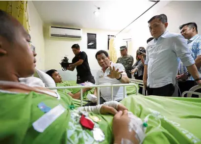  ?? —MALACAÑANG­PHOTO ?? COMMANDERI­NCHIEF President Duterte visits wounded soldiers at Metro Davao Medical and Research Center. He gifted one of them with a cow.