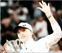  ?? ?? Iga Swiatek lifts the trophy after winning the women’s final against Coco Gauff in two sets, 6-1, 6-3, at the French Open on Saturday. (Photo by Thibault Camus, AP)