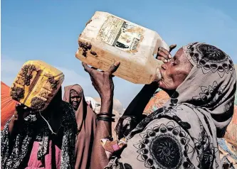  ?? AFP ?? HAWA Mohamed Isack, right, drinks water at a water distributi­on point at Muuri camp, one of the 500 camps for internally displaced persons in Baidoa, Somalia. United Nations humanitari­an chief Martin Griffiths warned this week that Somalia was ‘at the door of famine’ after being hit by four failed rainy seasons that has caused a devastatin­g drought, especially in the south central part of the country. |