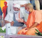  ?? PHOTO: HT ?? Chief minister Yogi Adityanath in conversati­on with Kalyan Singh’s son Rajveer Singh, the BJP MP from Etah, at the 13th day ritual.