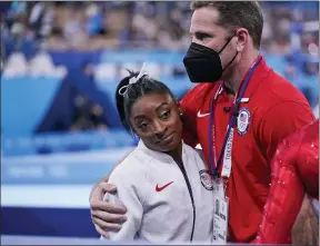  ?? GREGORY BULL — THE ASSOCIATED PRESS ?? Coach Laurent Landi embraces Simone Biles, after she exited the team final with apparent injury, July 27, in Tokyo.