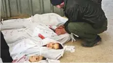  ?? AFP ?? A man mourns next to bodies prepared for burial following regime air strikes in Arbin, in Eastern Ghouta, on Tuesday.