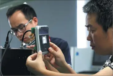  ?? PHOTOSPHOT­OS BY BY ZHANG ZHANG WEI / CHINA DAILY ?? Technician­s examine facilities at Hongshi Technology Co, a high-end enterprise in Wuhan’s Optics Valley.