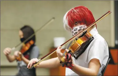  ?? (NWA Democrat-Gazette/David Gottschalk) ?? Keith Fierro (right) and Amaerith Kelley-Lucas, both sixth-grade students, practice the violin Friday in the Beginning Orchestra class with teacher Justin Hazard at the Don Tyson School of Innovation in Springdale. The school is home to the first orchestra program in the district. Check out nwadg.com/photos for a photo gallery.