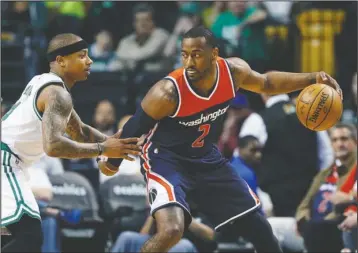  ?? The Associated Press ?? CELTIC MAGIC: Boston Celtics’ Isaiah Thomas, left, defends against Washington Wizards’ John Wall (2) during the first quarter of a second-round NBA playoff series game Sunday in Boston.