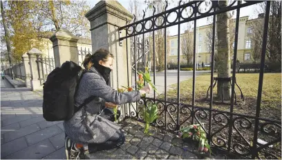  ?? Picture: AFP ?? IN MEMORIAM. Katarina Blennow lays flowers outside Malmö Latin School on Tuesday, the day after the attack where two women were killed in Malmoe, Sweden.